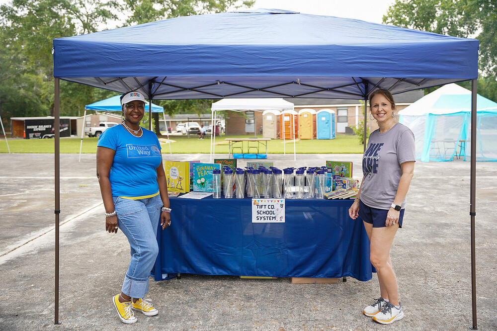 Two woman standing in the Tifton School system tent.
