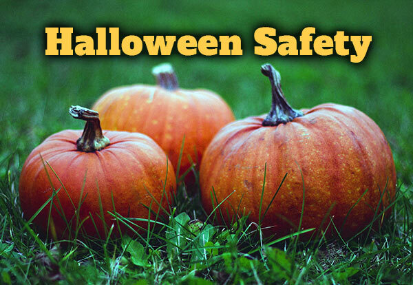 Three pumpkins sitting in the grass with the text Halloween Safety.