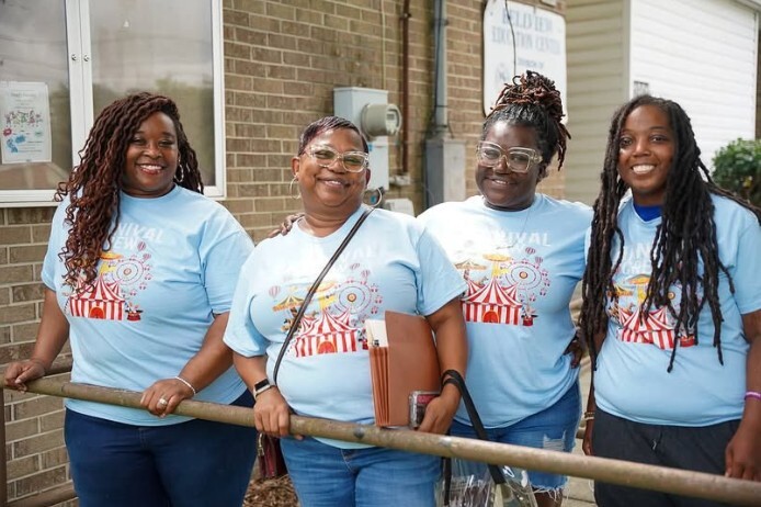 Four women standing and smiling for a photo.