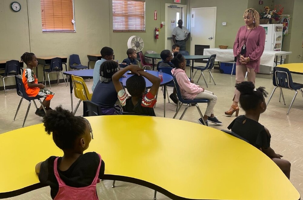 a classroom full of students listening to a teacher