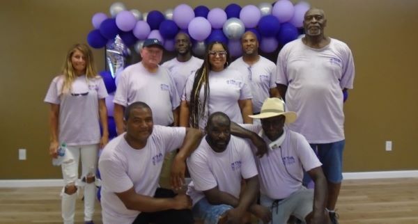 A group of Tifton Housing Authority employees standing in front of a balloon arch.