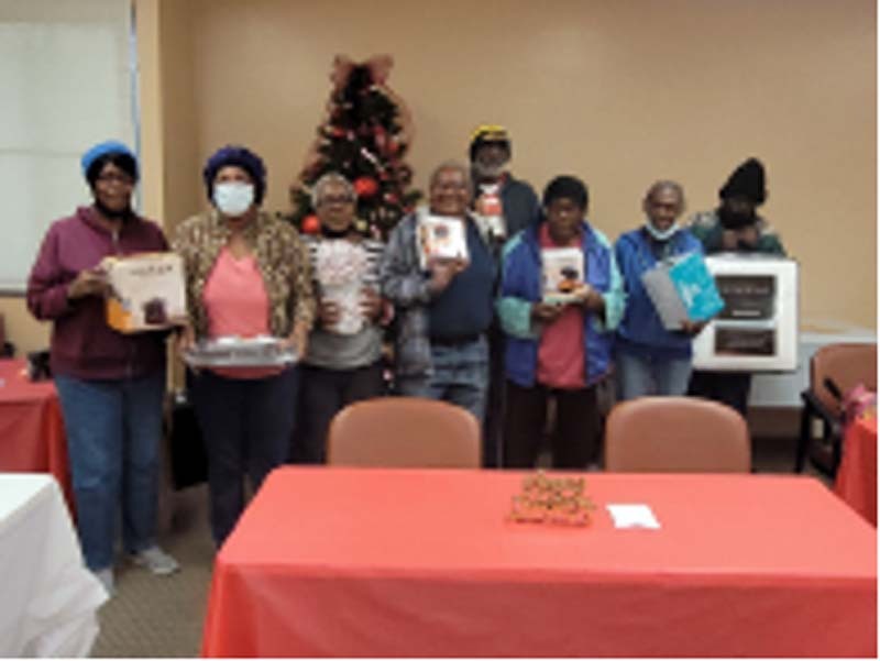 Elderly Village Senior Bingo participants stand together and show their prizes.