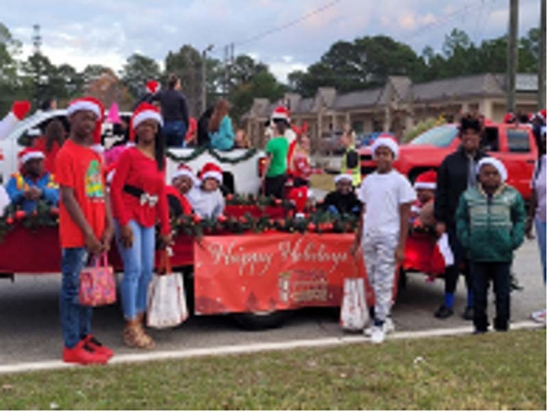 THA youth residents are standing around the THA Christmas Parade Float.