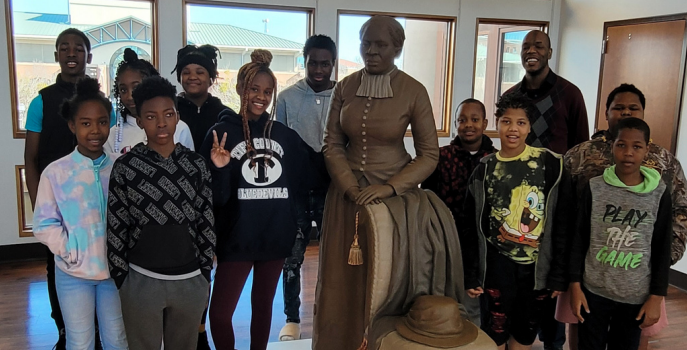 Youth standing around a statue of Harriet Tubman.