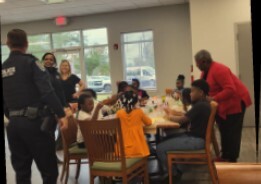 Children and adults at a table making snow globes at the Youth Center.