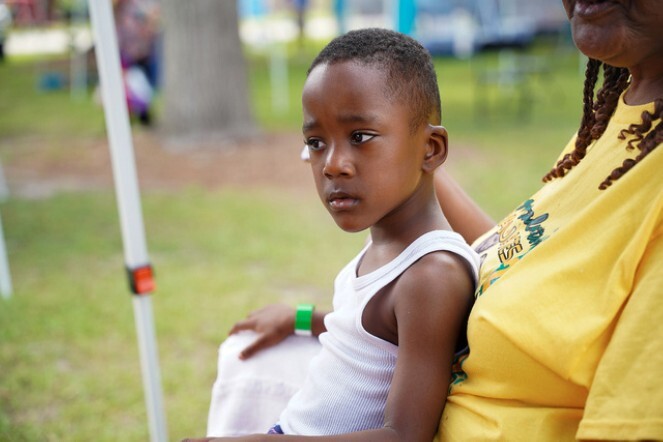 A young boy sitting on a woman's lap.