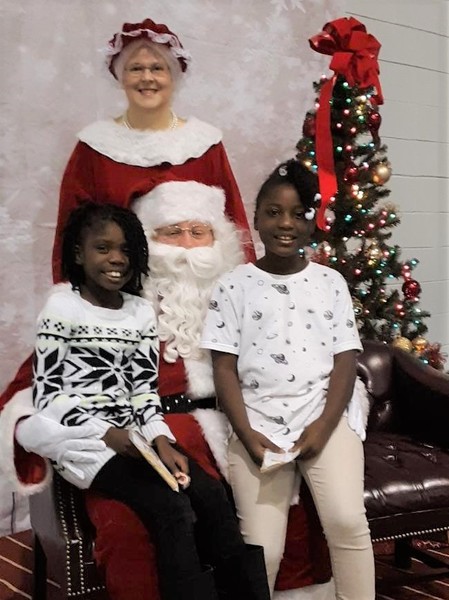 BreakfastwithSanta.jpg 2 little girls on Santa\'s lap with Mrs. Claus standing behind him