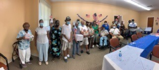 TIHAGABBQandBingowithElderlyVillageResidents.jpg Elderly Village Residents standing and sitting together for a group photo.