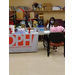 A resident sits at a table with a woman who is wearing a mask.