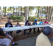 Residents are seated on one side of a long table. 