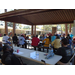 Residents are gathered together at tables under a pavilion.