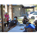 Residents are gathered together sitting at tables and standing to listen to the discussion.