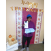 A resident stands in front of the photo backdrop and holds up her prize of new dish towels and wash cloths. 