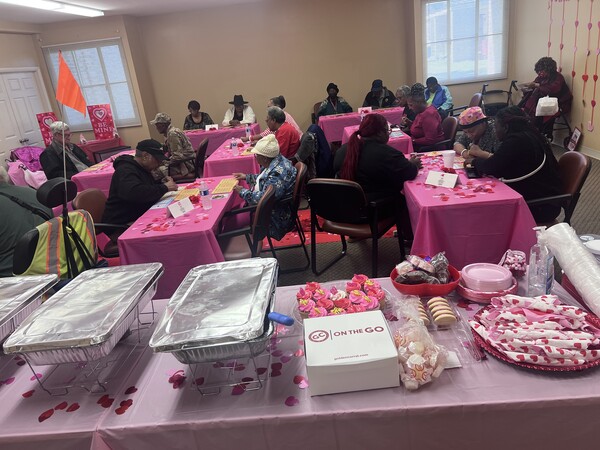 Elderly Village Valentine\'s Day attendees and food table.