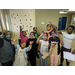  Nine kids smiling and holding up keychains that they made. 