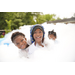  Three kids smiling and playing in a huge mountain of bubbles. 
