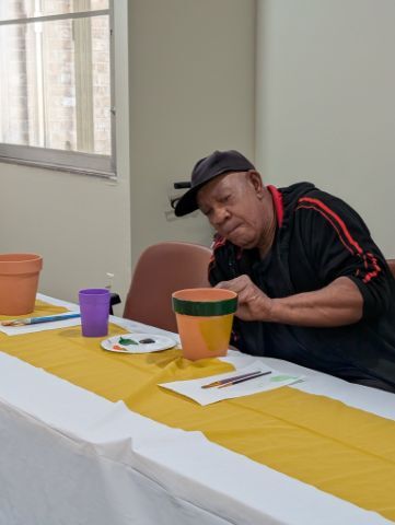 A man painting a terracotta pot. 