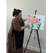  A woman painting flowers on a canvas. 